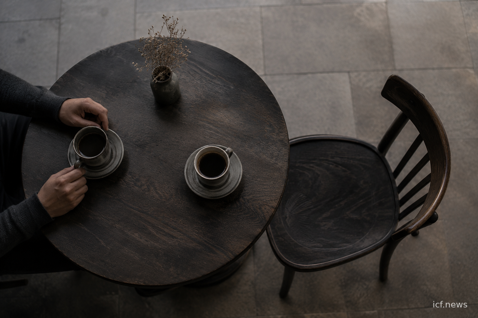 Table de café vue de dessus, deux tasses servies, une chaise vide