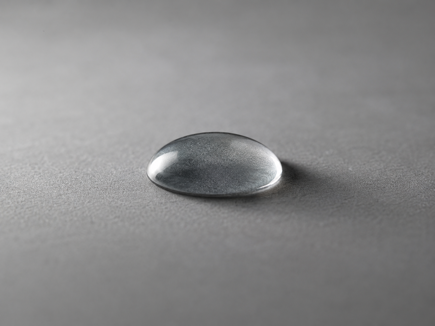 Goutte d'eau sur surface grise, macro